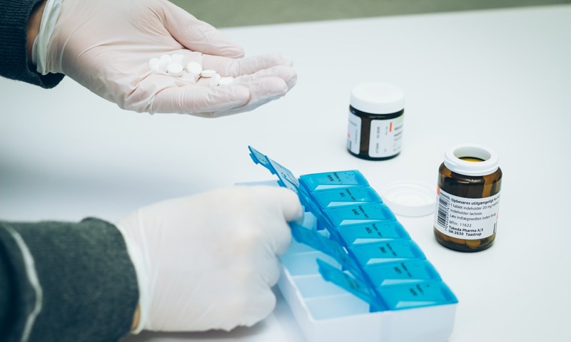 Person i gang med at dosere medicin Person i gang med at dosere medicin
